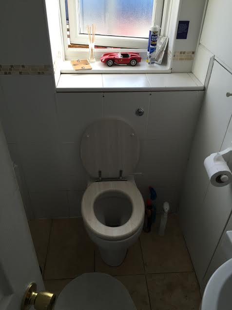 A toilet installed into the wall of a property