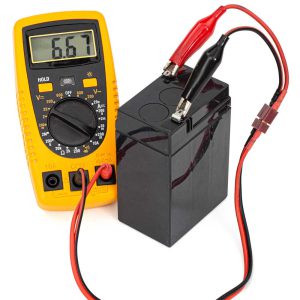 A multimeter being used to check the current from a battery